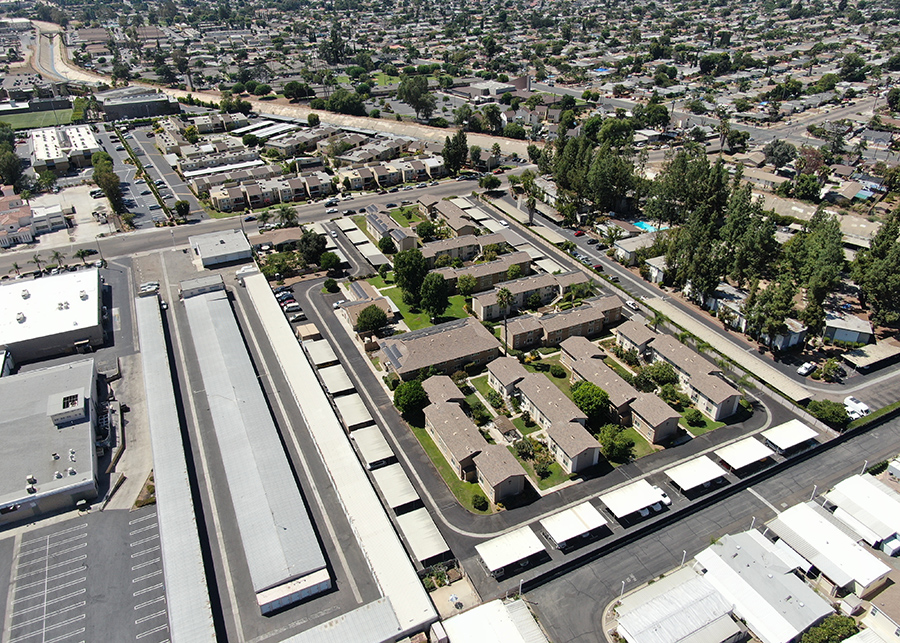 Aerial shot of the entire apartment complex, large solar panels stand out on the roofs of each building.